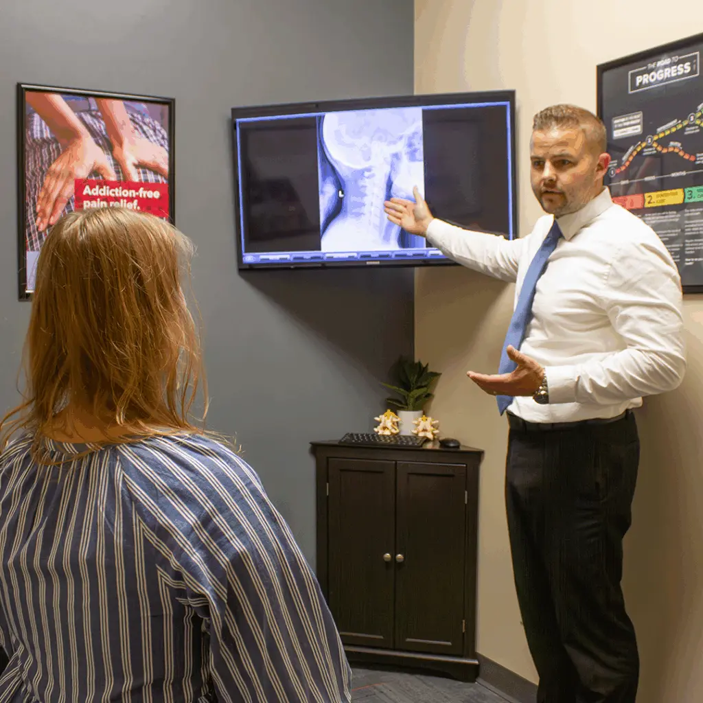 Dr. Andrew Krueger reviewing a spine X-ray with a new patient during a consultation
