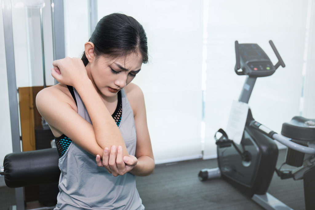 girl suffer from arm pain during exercise
