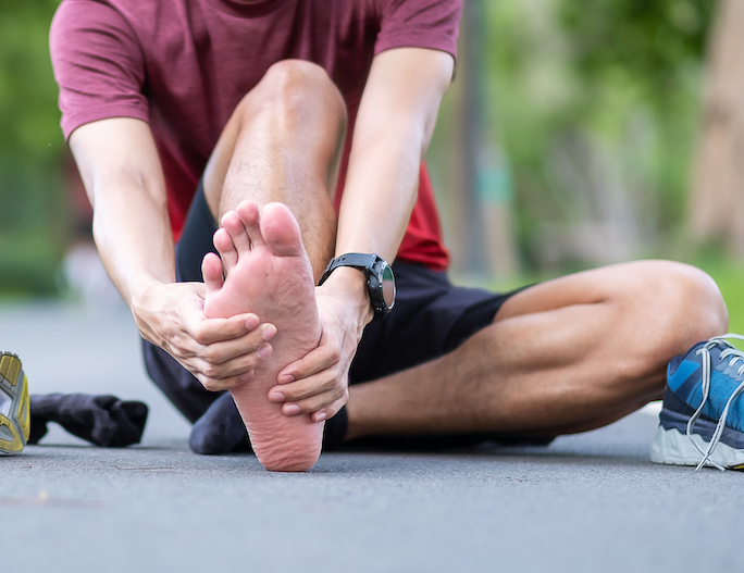 athletic man holding his plantar fasciitis pain